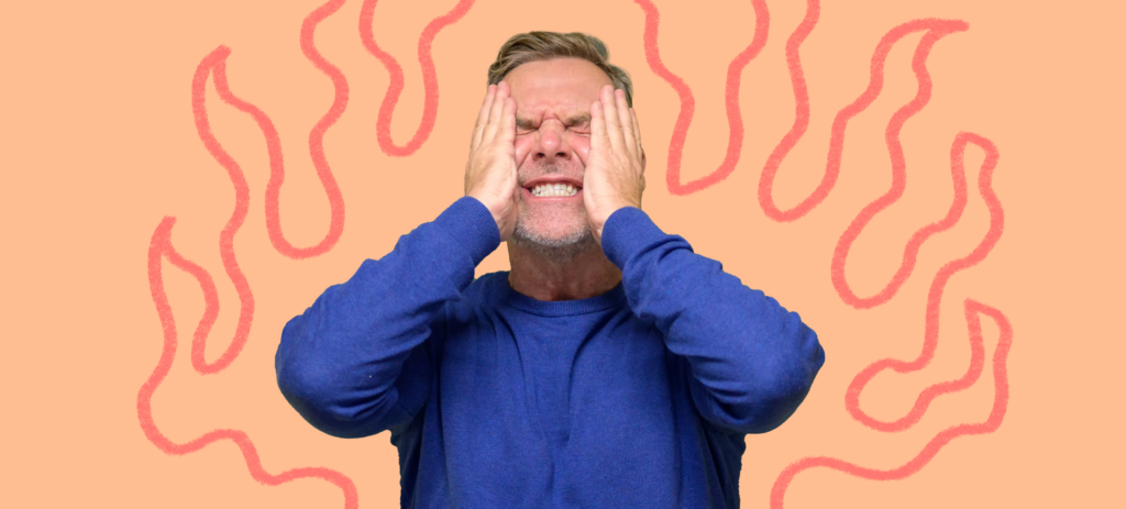 A male teacher presses his hands against his face in anger while experiencing burnout.