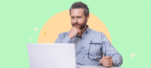 A man is looking at his laptop as he considers the best transition curriculum.