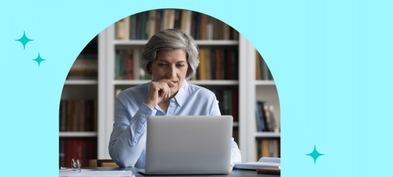 Educational leader selecting an SEL curriculum for their school or district. Female, grey-haired in front of an open laptop looking pensive.