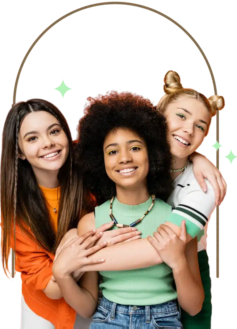 Three smiling girls of different ethnicities embracing each other in a friendly group portrait.
